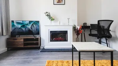 a living room with a tv and a fireplace at Comfy Spacious Home Near Preston City Centre - Sleeps 6 in Samlesbury