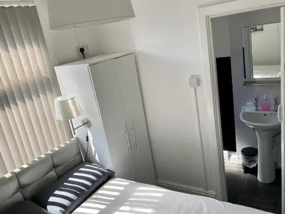 a bedroom with a bed and a sink and a mirror at The Hotel And Bar Blackpool in Blackpool