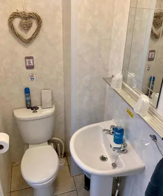 a bathroom with a white toilet and a sink at The Hotel And Bar Blackpool in Blackpool