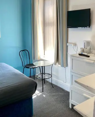 a bedroom with a bed and a table and chairs at The Hotel And Bar Blackpool in Blackpool