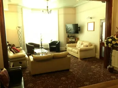a living room with two couches and a tv at Kirkstall Guest House in Blackpool