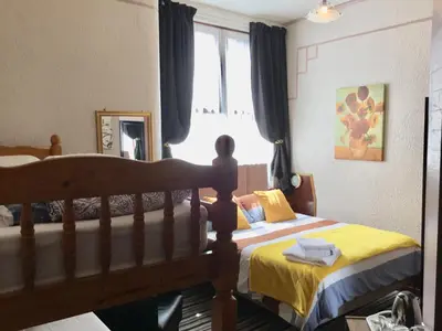 a bedroom with two beds and a window at Kirkstall Guest House in Blackpool