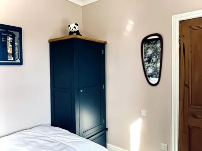 a bedroom with a panda bear on top of a blue cabinet at The Lytham Cottage in Lytham St Annes