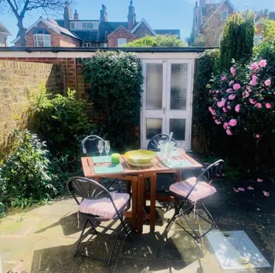 a table and four chairs in a garden at The Lytham Cottage in Lytham St Annes