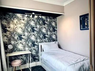 a bedroom with a bed and a black and white wallpaper at The Lytham Cottage in Lytham St Annes