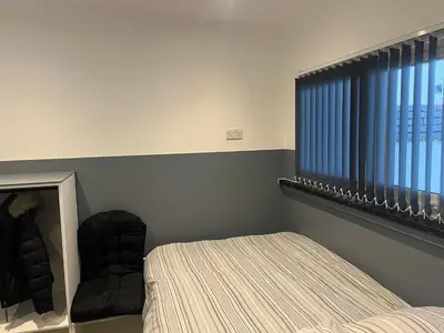 a bedroom with a bed and a mirror and a window at Townsend lane accommodation in Liverpool