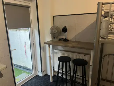 a kitchen with two stools and a counter with a window at Townsend lane accommodation in Liverpool