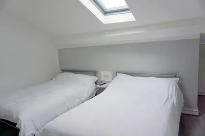 two beds sitting next to each other in a bedroom at Townsend lane accommodation in Liverpool