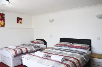 two beds in a room with white walls at The Gurkha Hotel in Blackpool