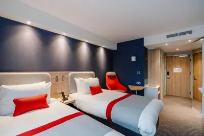 two beds in a hotel room with red accents at Holiday Inn Express Liverpool - Central by IHG in Liverpool