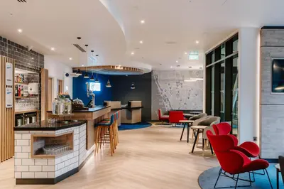 a living room with a fireplace and red chairs at Holiday Inn Express Liverpool - Central by IHG in Liverpool
