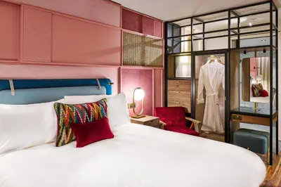 a bedroom with a white bed and a red chair at The Halyard Liverpool, Vignette Collection by IHG in Liverpool