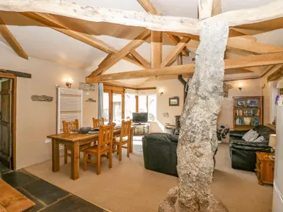 a dining room and living room with a wooden ceiling at Egg Pudding Stone in Grange Over Sands