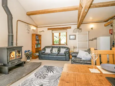 a living room with a wood stove and a couch at Egg Pudding Stone in Grange Over Sands