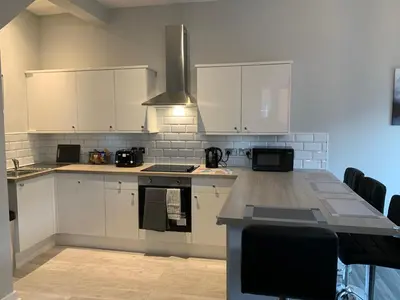 a kitchen with white cabinets and a counter top at Waterloo Sunset in Blackpool