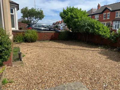 a backyard with a gravel driveway and a brick fence at Waterloo Sunset in Blackpool