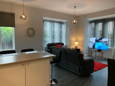 a living room with black chairs and a flat screen tv at Waterloo Sunset in Blackpool