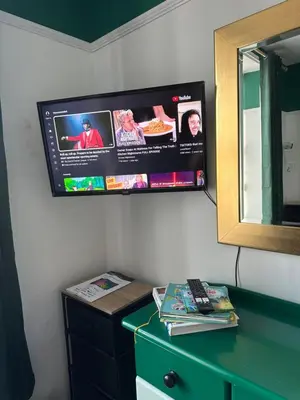 a tv on a wall with a green dresser at Emerald Apartment Pleasure Beach Blackpool in Blackpool