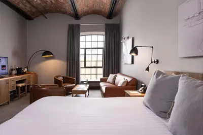 a bedroom with a bed and a living room at Titanic Hotel Liverpool in Liverpool