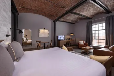 a bedroom with a large bed and a living room at Titanic Hotel Liverpool in Liverpool