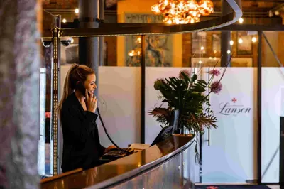 a woman talking on a cell phone at a counter at Titanic Hotel Liverpool in Liverpool