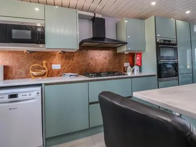a kitchen with blue cabinets and a black chair at 26 North Promenade in Cleveleys
