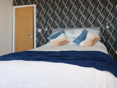 a bed with blue and white sheets and pillows at 26 North Promenade in Cleveleys