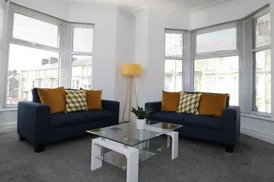 a living room with two blue couches and a coffee table at Ideal Base for Contractors in Central Morecambe- 3 Double Bedrooms in Morecambe
