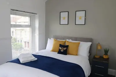 a bedroom with a large bed with yellow pillows at Ideal Base for Contractors in Central Morecambe- 3 Double Bedrooms in Morecambe