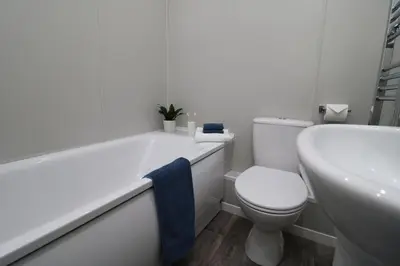 a white bathroom with a toilet and a tub and a sink at Ideal Base for Contractors in Central Morecambe- 3 Double Bedrooms in Morecambe