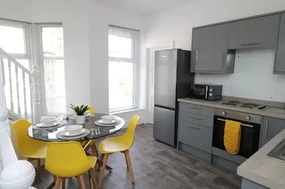 a kitchen with a table and yellow chairs in a kitchen at Ideal Base for Contractors in Central Morecambe- 3 Double Bedrooms in Morecambe