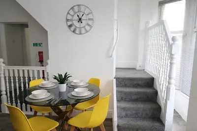 a dining room with a table and yellow chairs at Ideal Base for Contractors in Central Morecambe- 3 Double Bedrooms in Morecambe