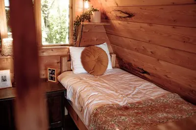 a bed in a wooden room with a window at Pattys Barn Holiday Cottages, Cabins and Venue Hire in Cockerham