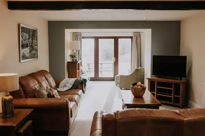 a living room with a couch and a tv at Pattys Barn Holiday Cottages, Cabins and Venue Hire in Cockerham