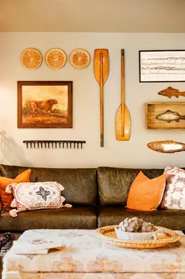a living room with a leather couch and utensils on the wall at Pattys Barn Holiday Cottages, Cabins and Venue Hire in Cockerham