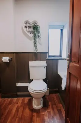 a bathroom with a white toilet and a window at Pattys Barn Holiday Cottages, Cabins and Venue Hire in Cockerham