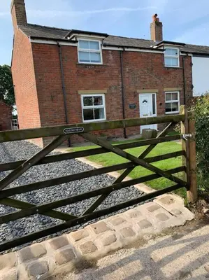a wooden gate in front of a brick building at Newton Hall Farm cottage, hot tub garden views Nr Lytham Ribby in Preston