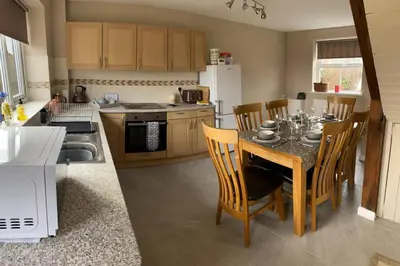 a kitchen with a table and chairs in a kitchen at Newton Hall Farm cottage, hot tub garden views Nr Lytham Ribby in Preston