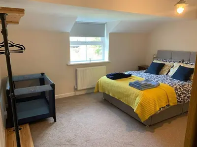 a bedroom with a bed with a yellow blanket at Newton Hall Farm cottage, hot tub garden views Nr Lytham Ribby in Preston