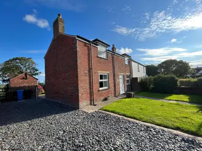 a brick house on a gravel driveway at Newton Hall Farm cottage, hot tub garden views Nr Lytham Ribby in Preston
