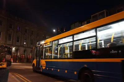a bus driving down a city street at night at Brecks Hotel in Blackpool