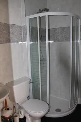 a bathroom with a white toilet and a shower at Brecks Hotel in Blackpool