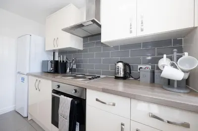 a kitchen with white cabinets and white appliances at Contemporary 3 Bedroom Home with Garden & Parking in Atherton