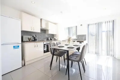 a kitchen with a table and chairs in a room at Contemporary 3 Bedroom Home with Garden & Parking in Atherton