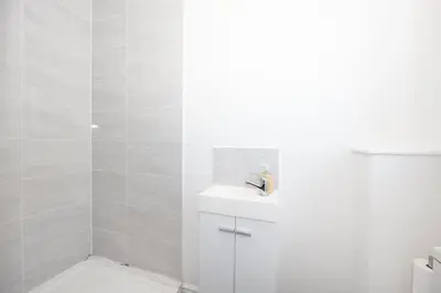 a white bathroom with a toilet and a sink at Contemporary 3 Bedroom Home with Garden & Parking in Atherton