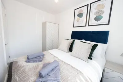 a bedroom with a bed with blue and white pillows at Contemporary 3 Bedroom Home with Garden & Parking in Atherton