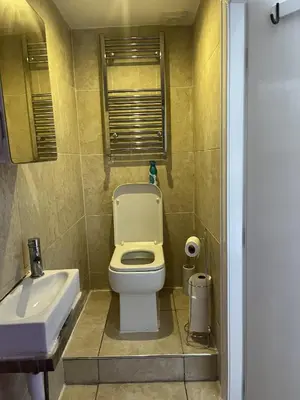 a small bathroom with a toilet and a sink at Moorside House in Bolton