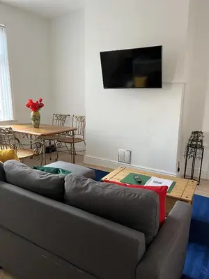 a living room with a gray couch and a table at Moorside House in Bolton