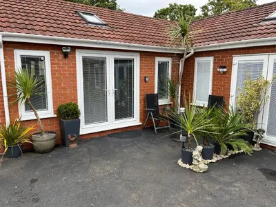a house with a lot of plants in front of it at Happy days Moreton , 2 miles from Hoylake Wirral in Moreton
