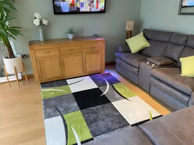 a living room with a couch and a checkered rug at Happy days Moreton , 2 miles from Hoylake Wirral in Moreton
